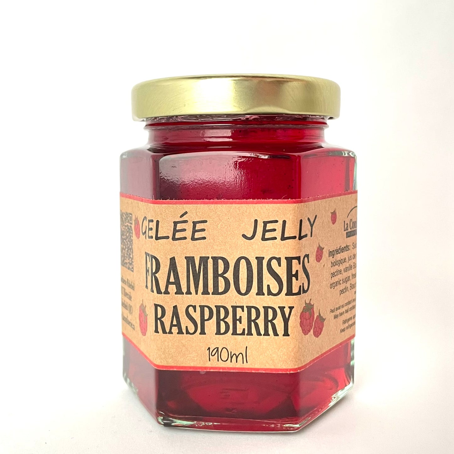 Jar of raspberry jelly with a gold lid on a white background